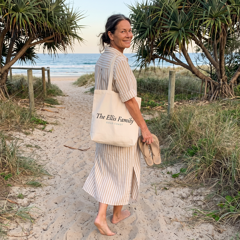 Woman on the sandy path at Currumbin Beach in a beige striped midi dress
